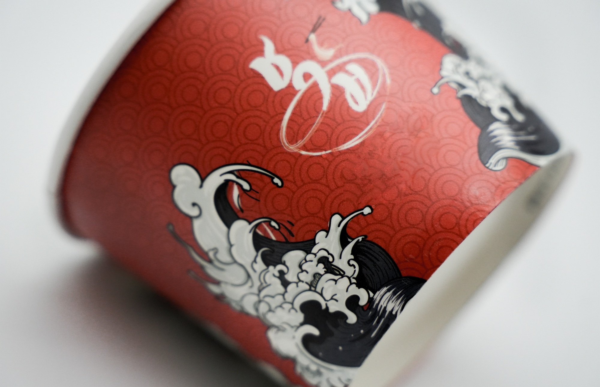 Close-up of a red product packaging with white and black designs on a white background